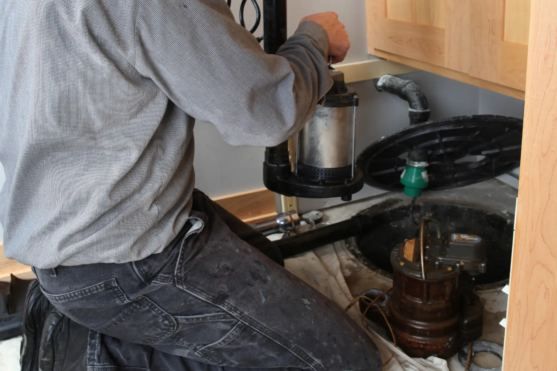 Plumber installing a sump pump