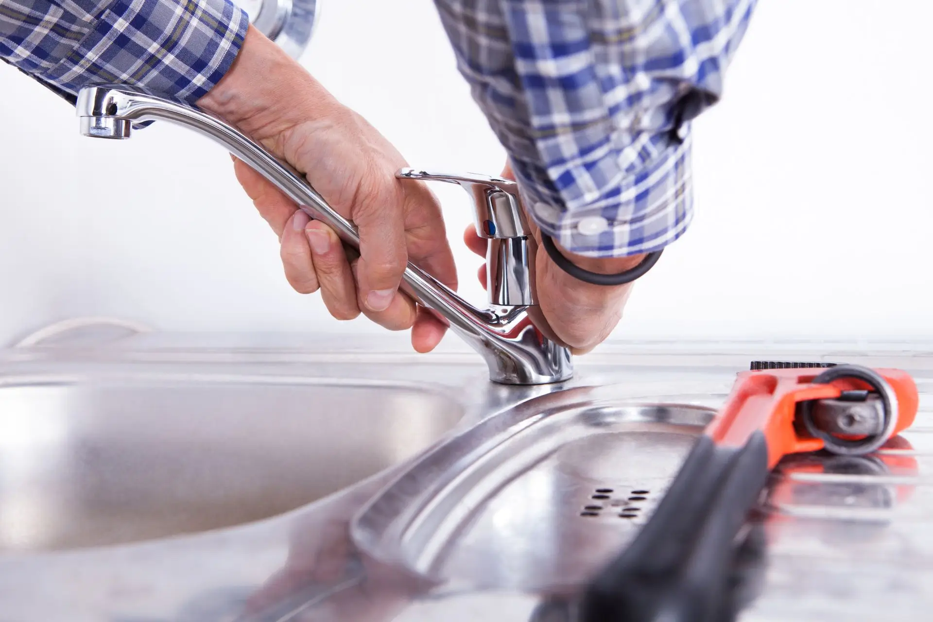 A plumber fixing a single-handle kitchen faucet