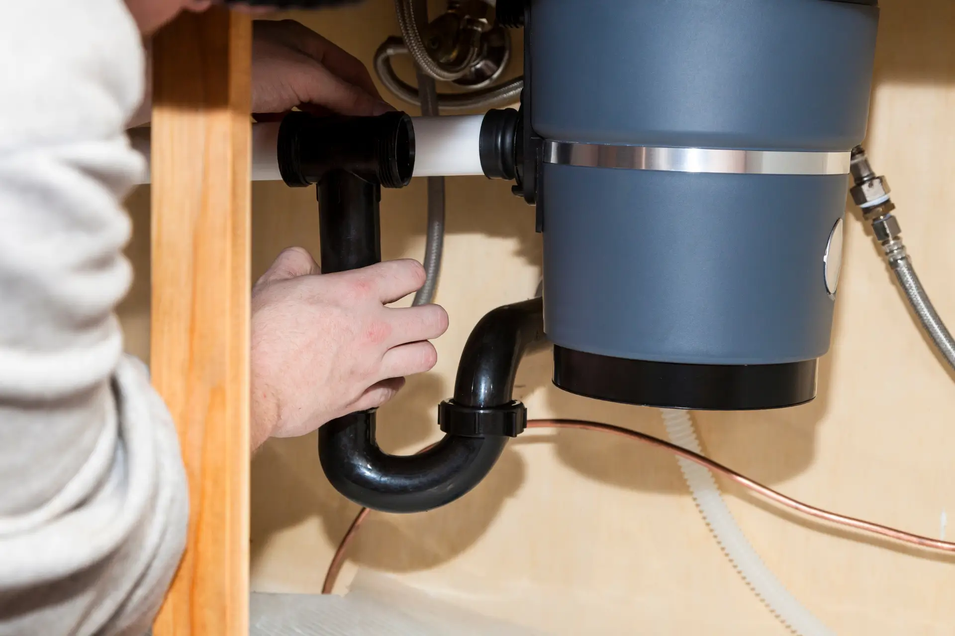 Plumber fixing garbage disposal