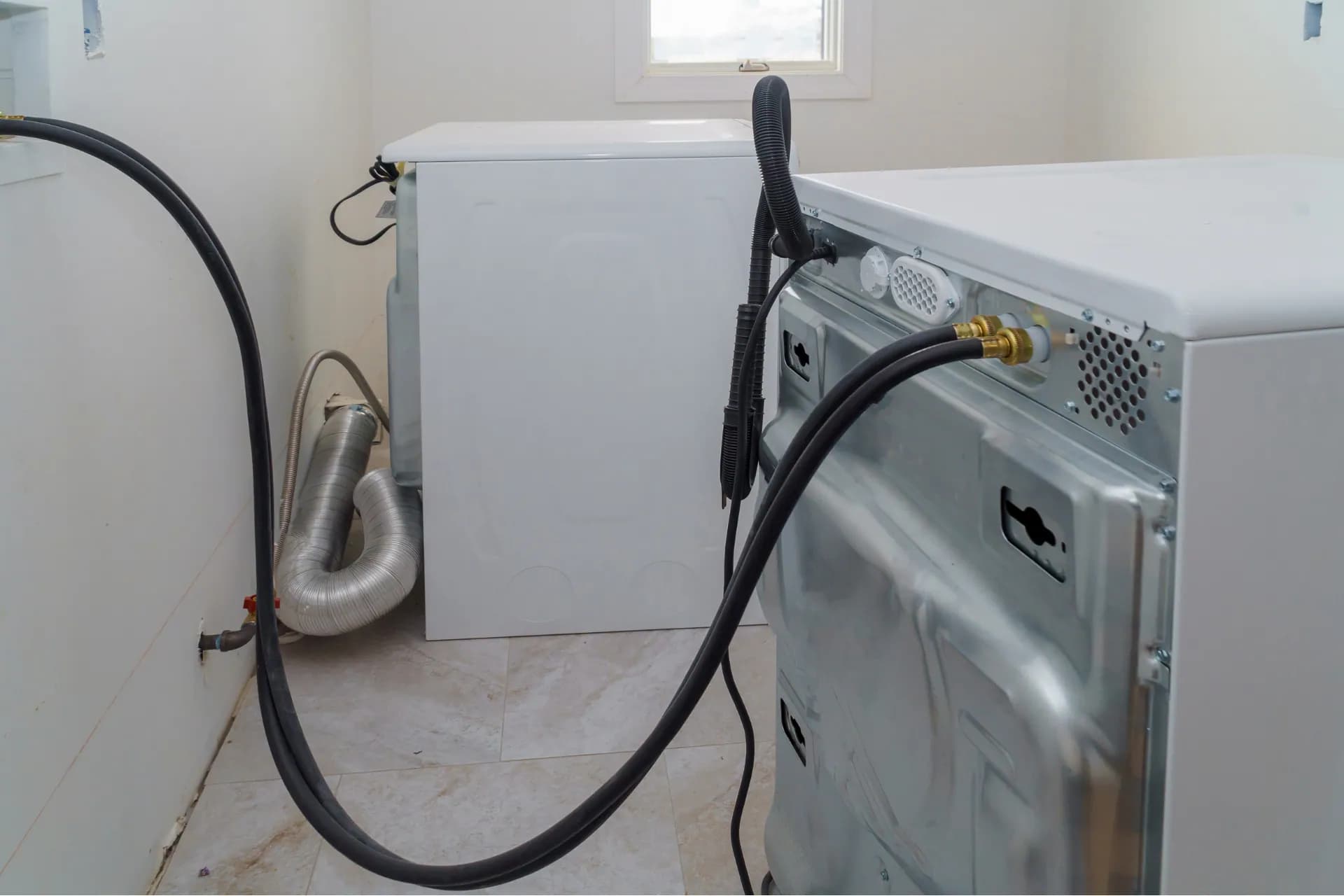 A washing machine has its drain hose installed 