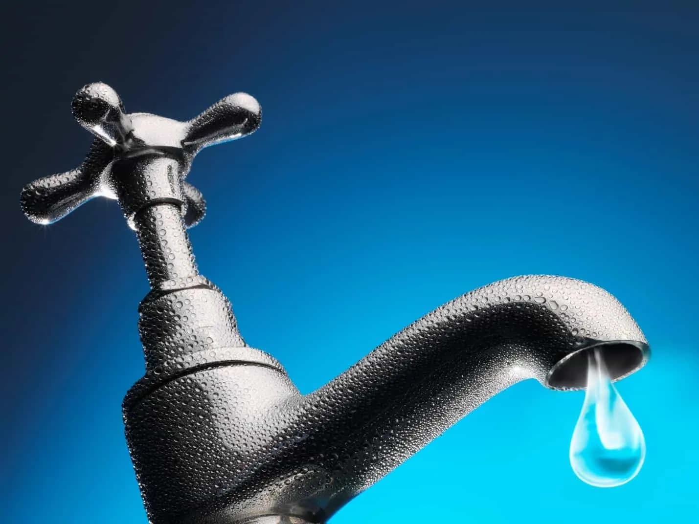 Close up of a sink tap dripping water