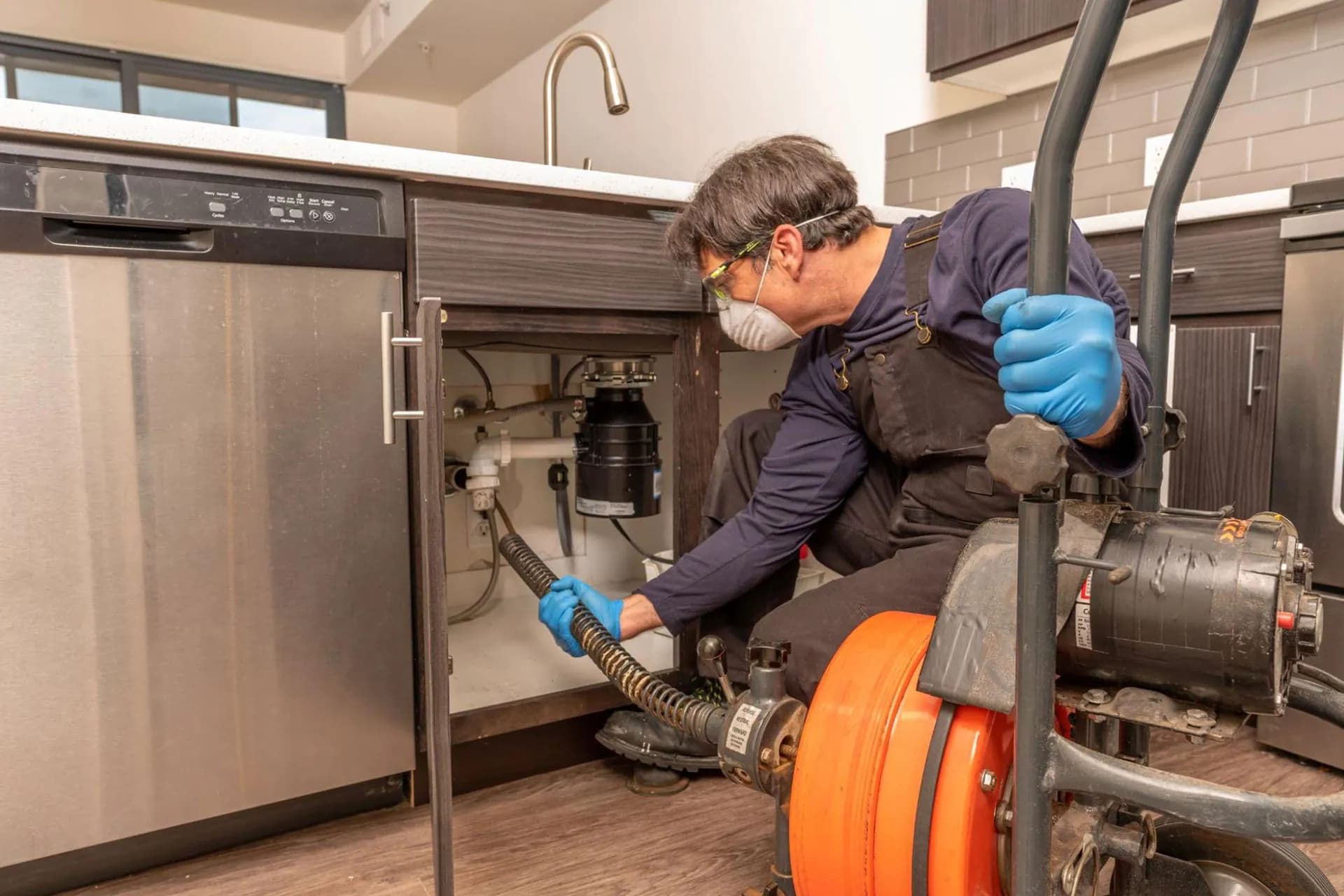 A professional plumber carrying out drain cleaning services