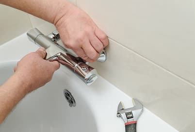 Bathtub drain and faucet being repaired