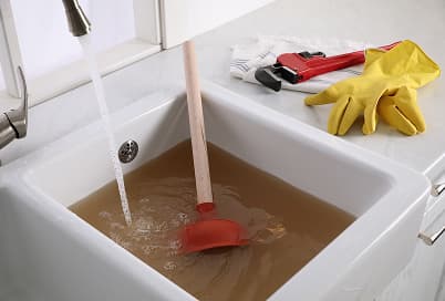 Clogged sink drain being cleared