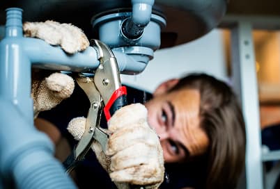 Plumber checking a pipe for a hidden leak