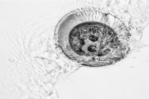 Close up of a clogged drain’s water flowing after fix