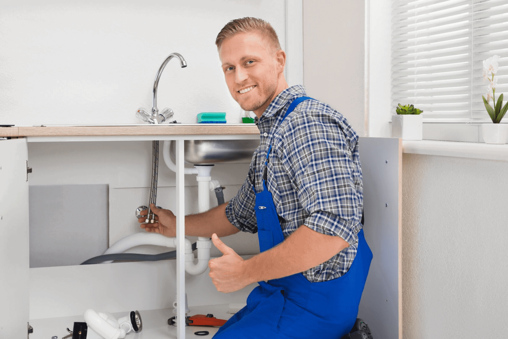 Professional plumber in Hamilton fixing a bathroom sink