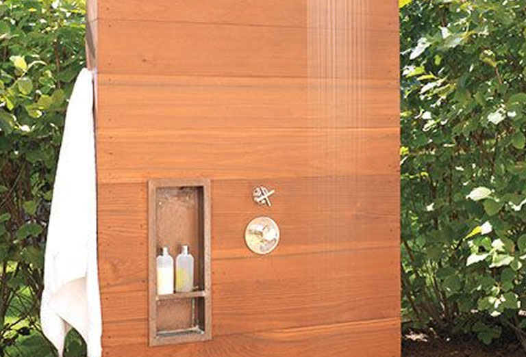 Outdoor shower with a cedar wall and recessed shelves