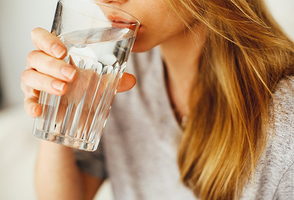 Close up of a woman drinking a glass of water