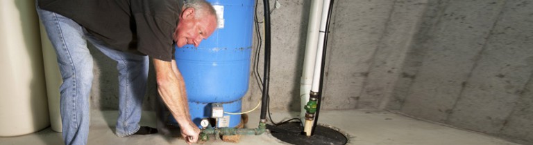 A man applying finishing touches on a newly-installed sump pump