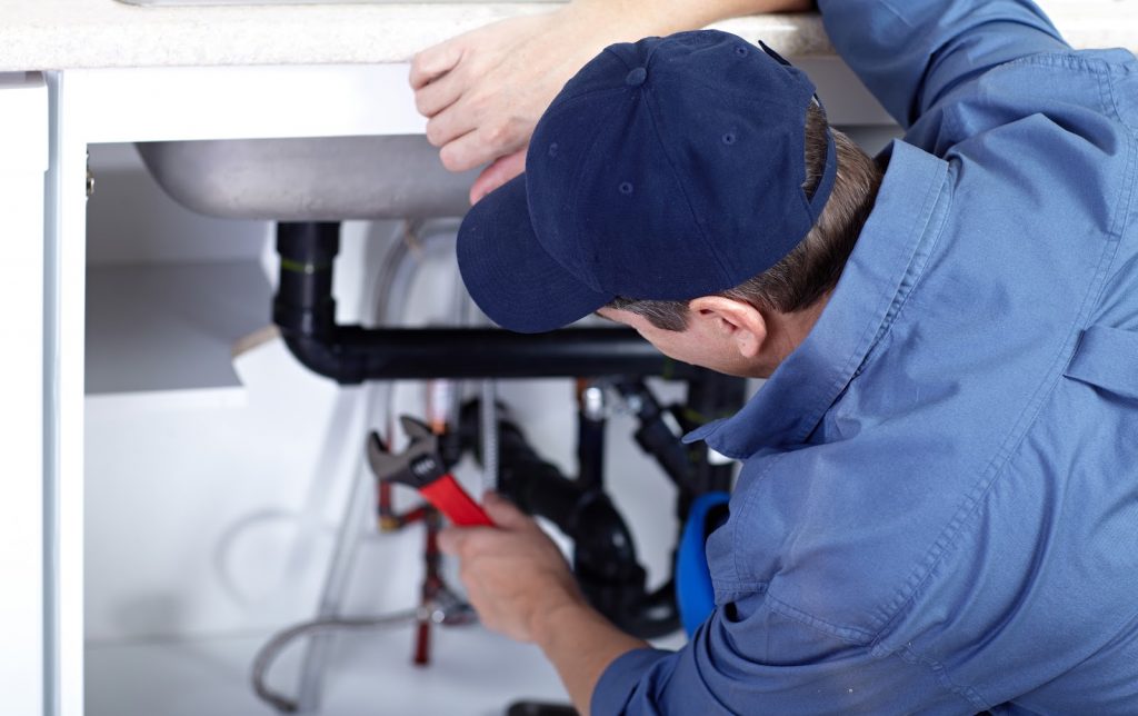 Closeup of a plumber working on a sink drain