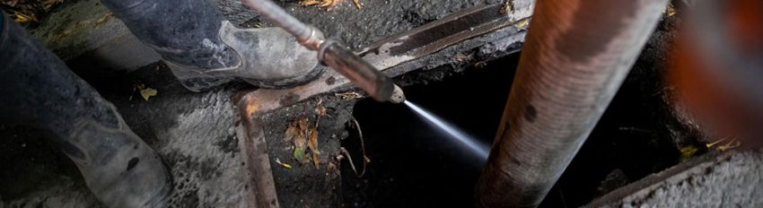 Plumbers hydro jetting a pipeline