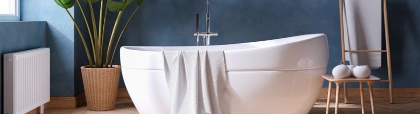 A soaking bathtub with towel draped over it