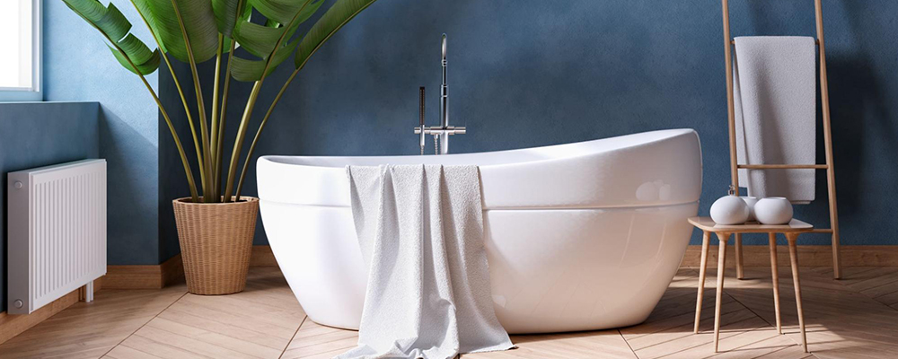 A soaking bathtub with towel draped over it