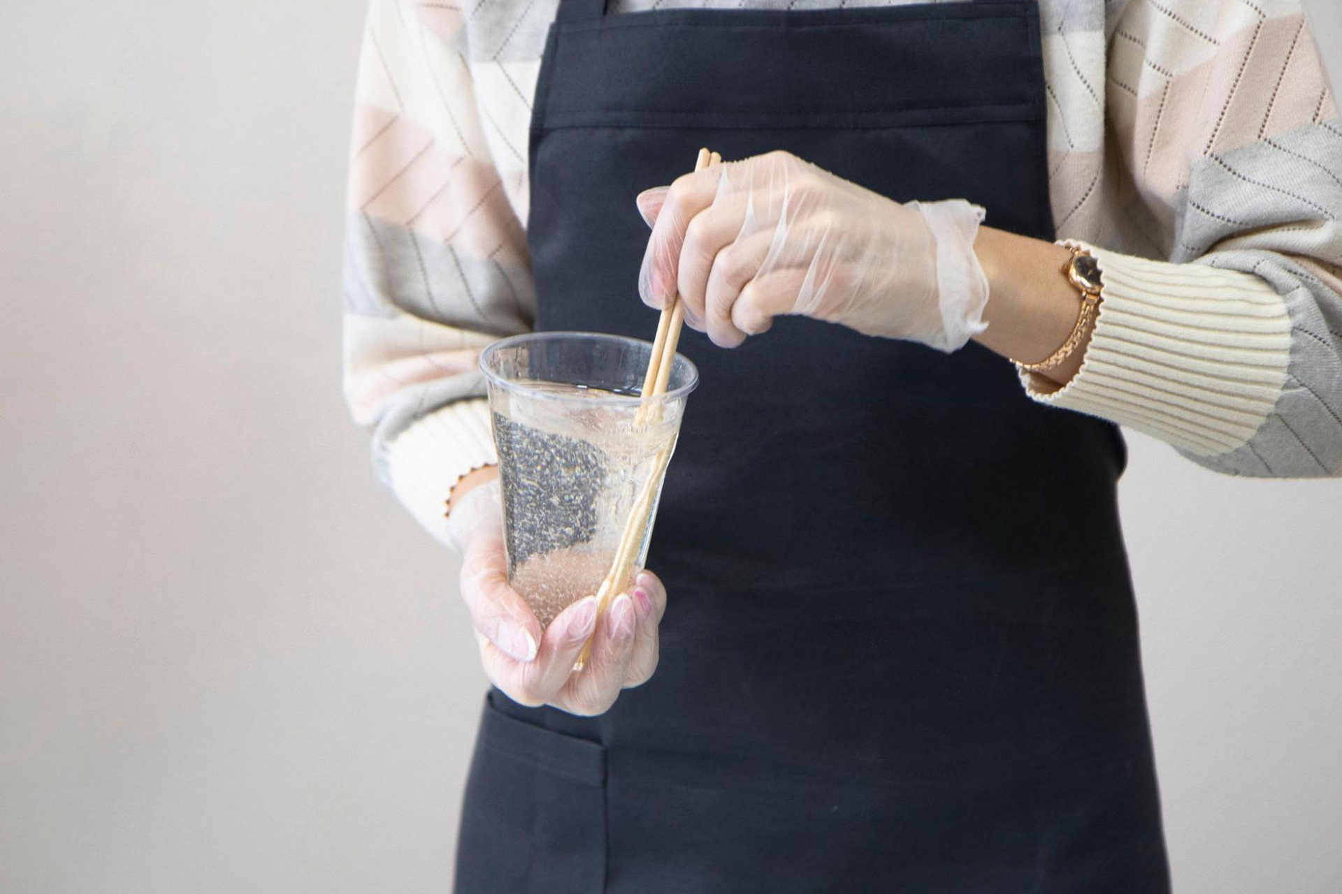 A person wearing an apron mixing epoxy for a cracked sink repair