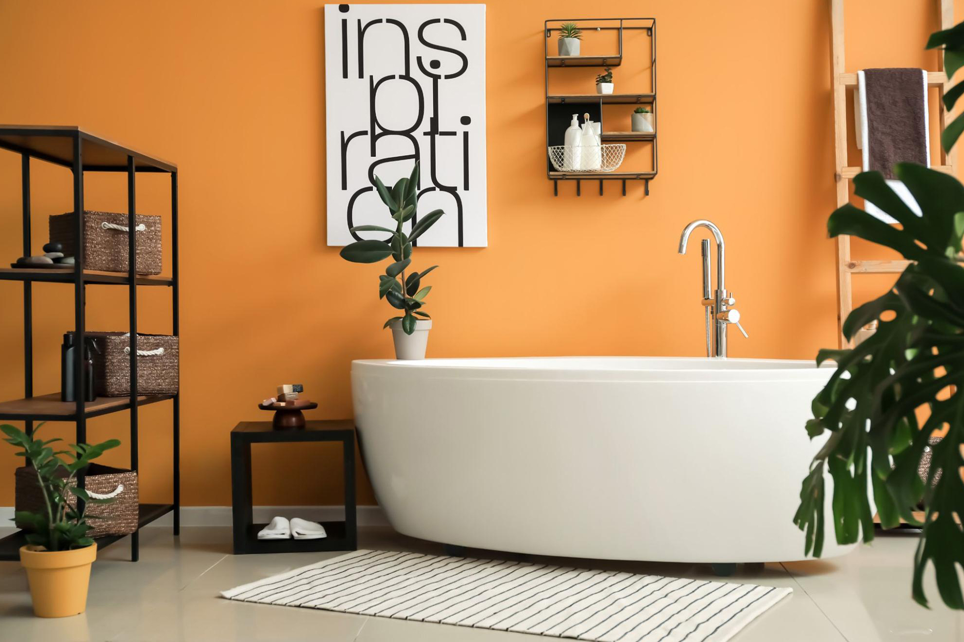 A cast iron bathtub in a bathroom with orange hues