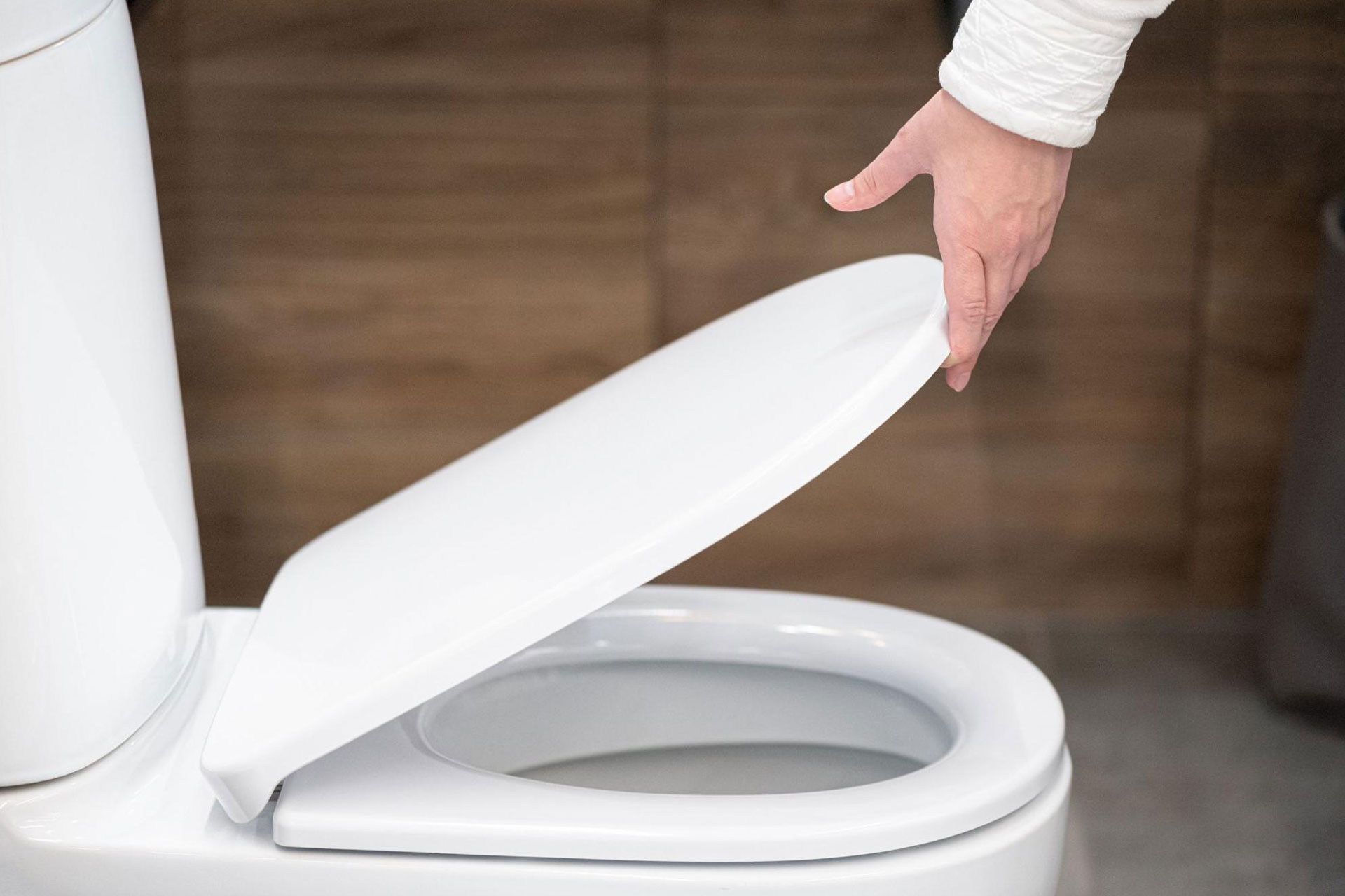 A close-up of someone inspecting a porcelain toilet