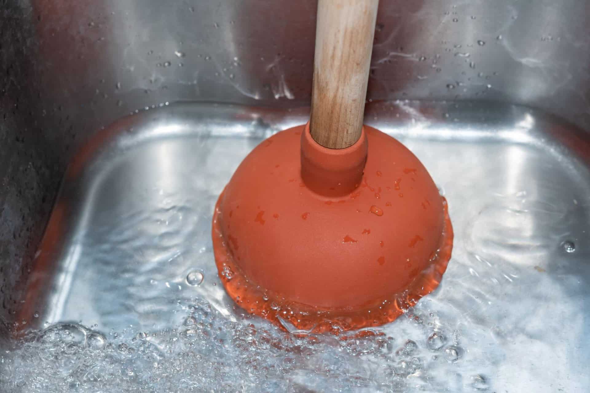 Close-up of a plunger trying to unclog a drain, a problem that might need a drain camera inspection