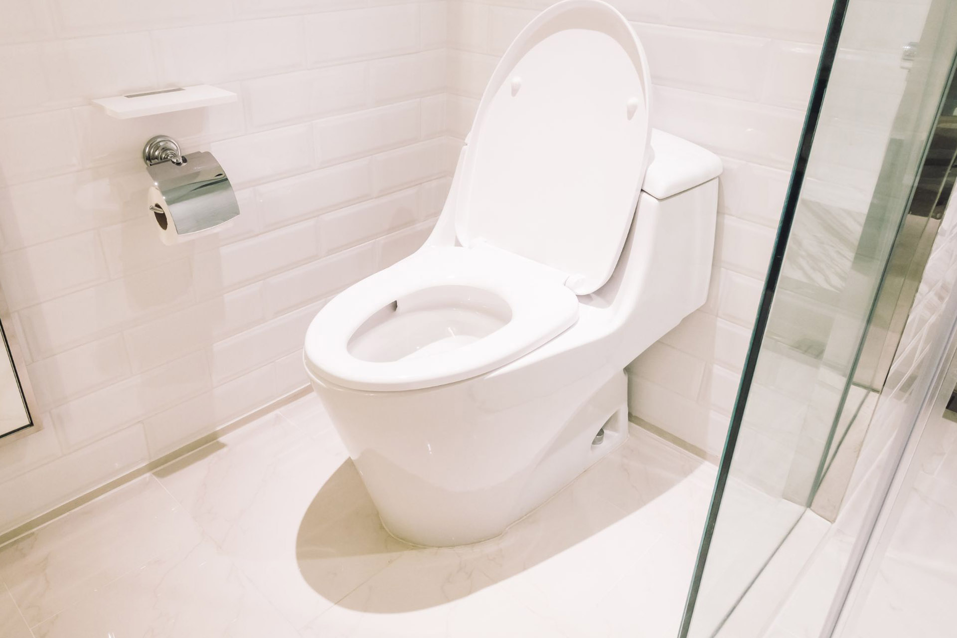 A toilet in a bathroom with a white motif