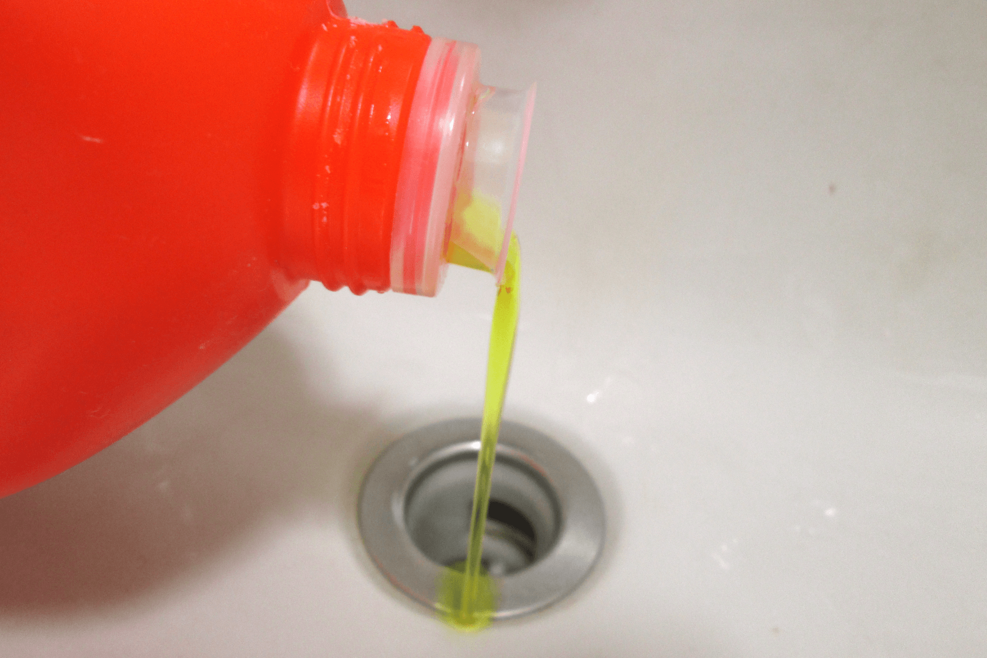 Cleaning solution being poured down a drain 