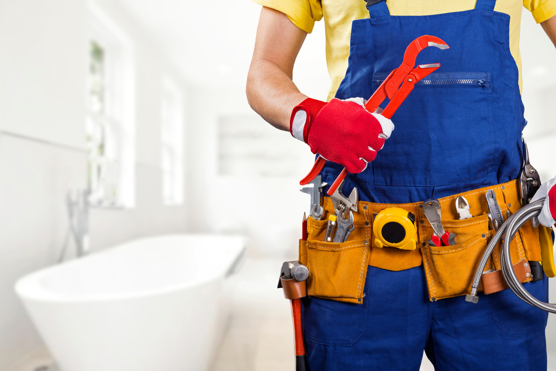 A plumber standing ready in front of a bathtub