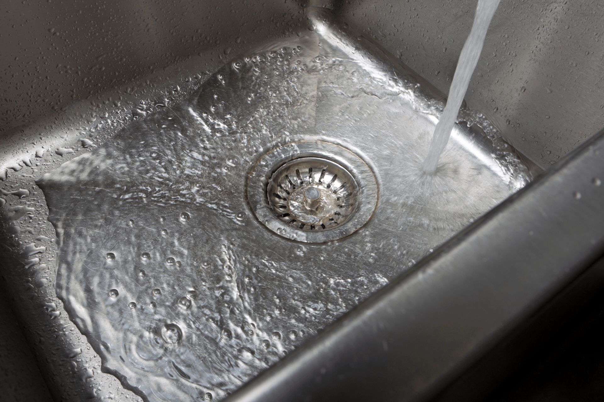 Water flows into a slow draining kitchen sink