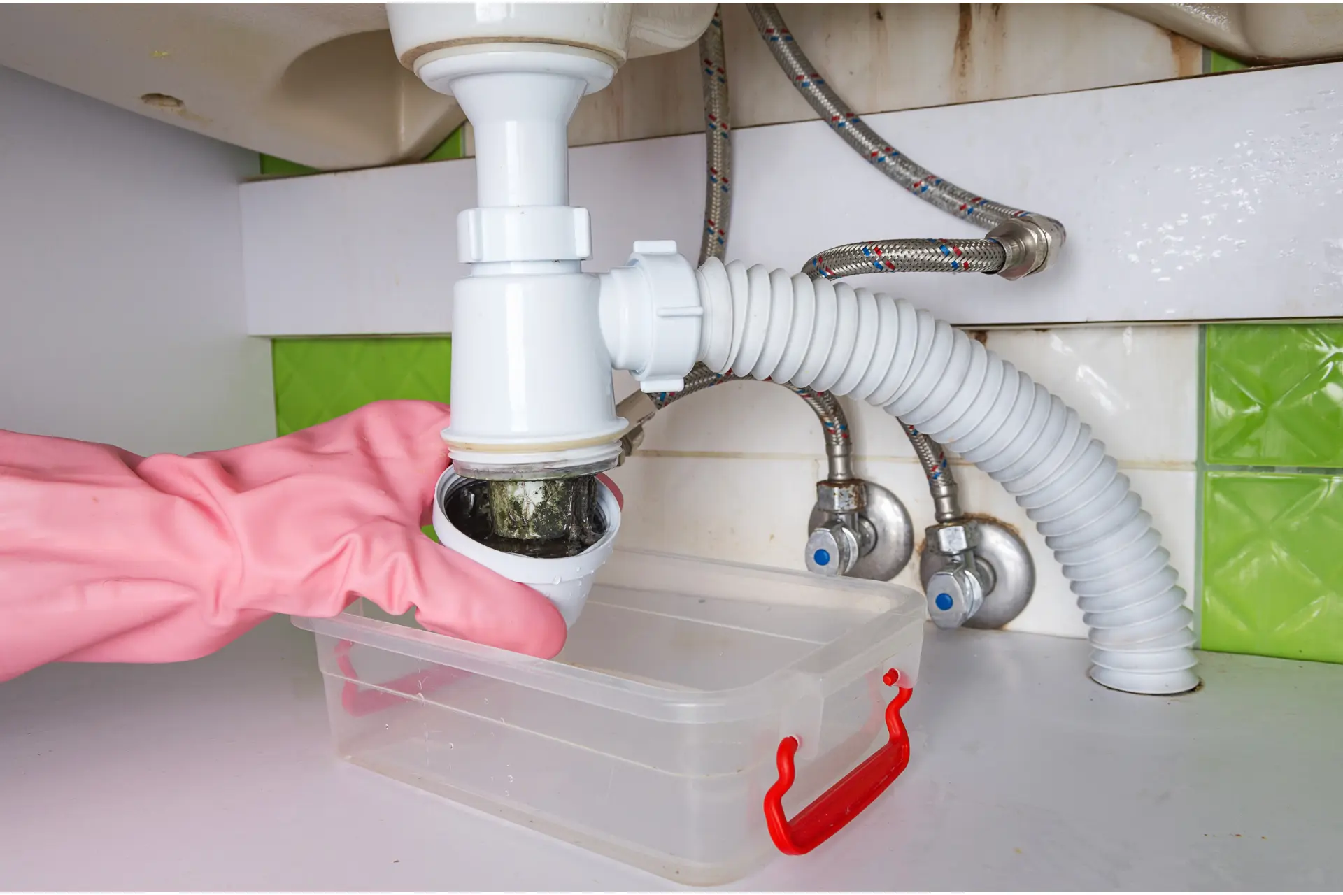 a person removes the p-trap of a clogged drain of a bathroom sink
