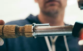 A male plumber in a blue jumpsuit fixing pipes