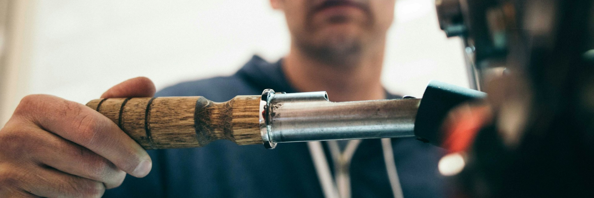 A male plumber in a blue jumpsuit fixing pipes
